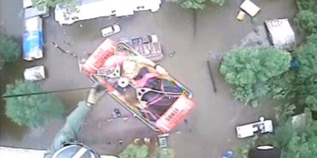An aircrew from Coast Guard Air Station New Orleans rescues three people from a rooftop due to flooding in Baton Rouge, Louisiana, U.S., A in this still image from video taken on August 13, 2016. Coast Guard Air Station New Orleans/Handout via REUTERS ATTENTION EDITORS - THIS IMAGE WAS PROVIDED BY A THIRD PARTY. EDITORIAL USE ONLY