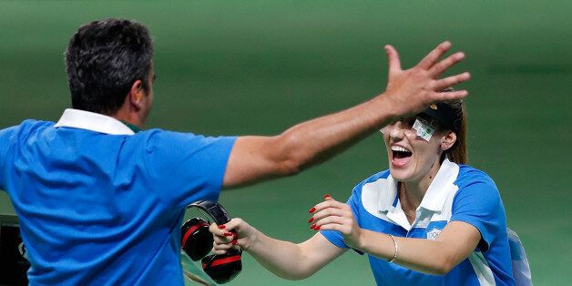 Anna Korakaki (R) of Greece celebrates with her coach, also her father after the women's 25m pistol final of shooting at the 2016 Rio Olympic Games in Rio de Janeiro, Brazil, on Aug. 9, 2016. Anna Korakaki won the gold medal./ CHINA OUT