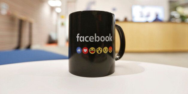 The Facebook logo and emoticons are seen on a coffee mug at the reception of its new office in Mumbai, India May 27, 2016. REUTERS/Shailesh Andrade