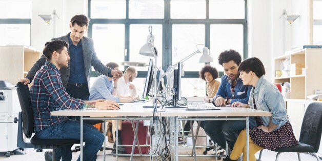 Start-up business team on desks working in bright office loft.