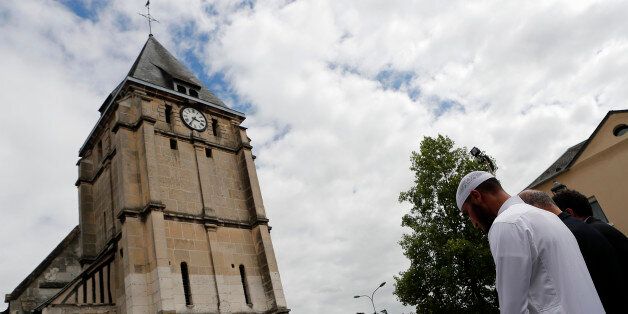 Muslim worshippers hold a minute of silence in front of the memorial at the Saint Etienne church in Saint-Etienne-du-Rouvray, Normandy, France, Friday, July 29, 2016. Four days after the hostage taking in Saint-Etienne-du-Rouvray, officials and worshippers of the muslim community paid tribute to Priest Jacques Hamel and Christian community after the friday prayer at the Yahya Mosque. (AP Photo/Francois Mori)