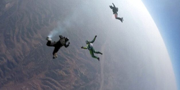 In this image made from a video provided by Mondelez International, Luke Aikins, center, skydives without a parachute over Simi Valley, Calif., Saturday, July 30, 2016. After a two-minute freefall, Aikins landed dead center in the 100-by-100-foot net at the Big Sky movie ranch. Aikins made history Saturday when he became the first person to leap without a parachute and land in a net instead. (Mondelez International via AP)
