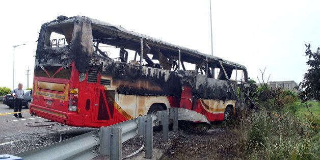 Investigators inspect a bus carrying tourists from mainland China that crashed and caught fire along an expressway on its way to the airport in Taiwan's city of Taoyuan on July 19, 2016.The Taiwan tour bus carrying visitors from mainland China crashed and caught fire on July 19 near the capital Taipei, killing 26 on board. / AFP / Sam YEH (Photo credit should read SAM YEH/AFP/Getty Images)