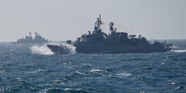 Turkish NATO warship TCG Turgutreis, foreground, maneuvers on the Black Sea after leaving the port of Constanta, Romania, Monday, March 16, 2015, as an explosion takes place in the distance. NATO ships take part in sea military exercises in the Black Sea region involving ships USS Vicksburg, as well as a German auxiliary ship and frigates from Canada, Turkey, Italy and Romania. (AP Photo/Vadim Ghirda)