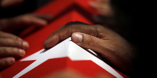 A hand rests on a coffin during a funeral service for victims of the thwarted coup at Fatih Mosque in Istanbul, Turkey, July 17, 2016. REUTERS/Alkis Konstantinidis