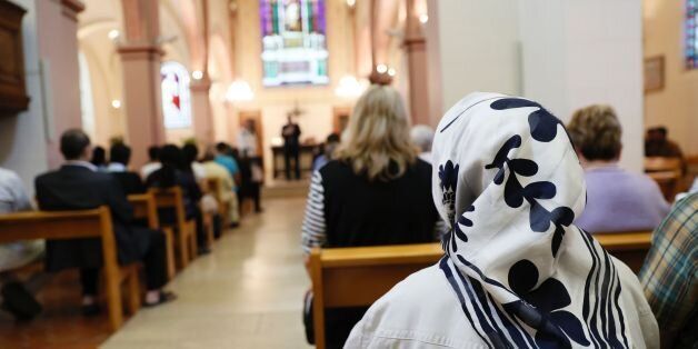 A Muslim faithful woman sits as she attends a Mass in tribute to priest Jacques Hamel at the Saint-Leu Saint-Gilles Bagnolet's Church, near Paris, on July 31, 2016.Muslims across France were invited to participate in Catholic ceremonies today to mourn a priest whose murder by jihadist teenagers sparked fears of religious tension. Masses will be celebrated across the country in honour of octogenarian Father Jacques Hamel, whose throat was cut in his church on July 26, 2016 in the latest jihadist attack on France. / AFP / Thomas SAMSON (Photo credit should read THOMAS SAMSON/AFP/Getty Images)