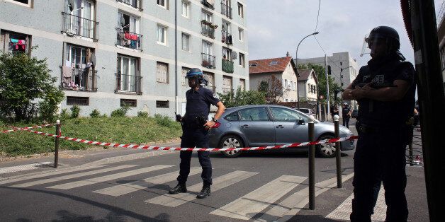 Riot police stand guard next to a building where French anti-terrorist forces conducted raids, in Argenteuil, west of Paris, Thursday, July 21, 2016. A top security official said both France's top counter-terrorism organization, the DGSI, and the country's elite police were involved in the Thursday raids that targeted two private residences. (AP Photo/Thibault Camus)