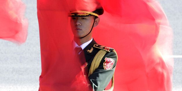 A soldier from the honour guards holding a red flag stands during a welcoming ceremony for Germany's Chancellor Angela Merkel outside the Great Hall of the People in Beijing, China, October 29, 2015. REUTERS/Jason Lee/File Photo