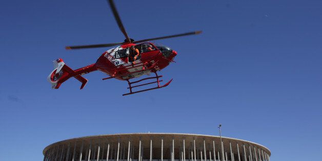 A fire department helicopter flies over as part of an exercise drill simulating security forces reaction to a chemical attack outside the National Stadium, which will host 2016 Summer Olympics soccer matches in Brasilia, Brazil, Thursday, July 28, 2016. Double the number of military and police are expected to patrol during the games, compared to London in 2012, and while most will be concentrated at sporting venues, tourist landmarks will also be heavily patrolled. (AP Photo/Eraldo Peres)