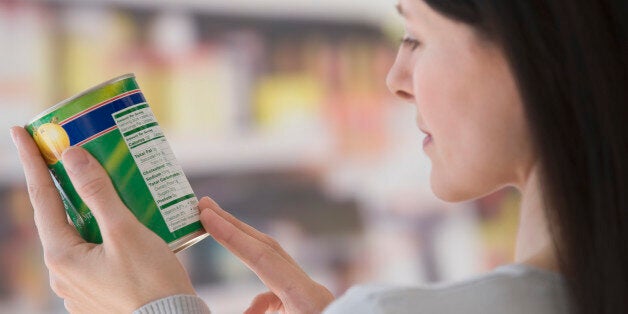 Woman reading label at grocery store