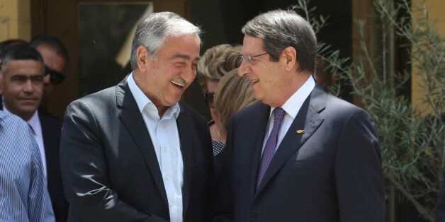 Greek Cypriot leader and Cyprus President Nicos Anastasiades (R) shakes hands with Turkish Cypriot leader...