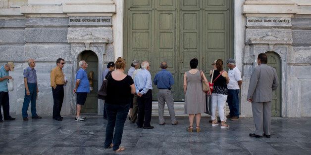Athens residents wait for a branch of the National Bank of Greece to open in central Athens on Tuesday, June 28, 2016. Greece introduced capital controls for bank transactions a year ago amid financial turmoil triggered by bailout negotiation delays. Country residents can still withdraw a maximum of 420 euros (around $465) a week. (AP Photo/Petros Giannakouris)
