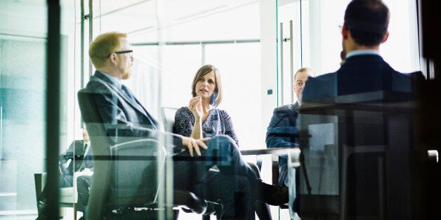 Female business executive leading meeting in office conference room