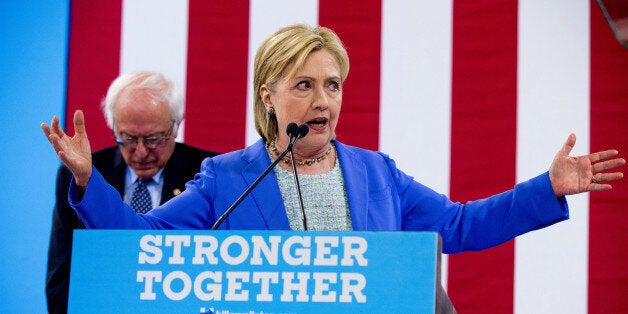 Sen. Bernie Sanders, I-Vt. listens as Democratic presidential candidate Hillary Clinton speaks during a rally in Portsmouth, N.H., Tuesday, July 12, 2016, where Sanders endorsedClinton for president. (AP Photo/Andrew Harnik)