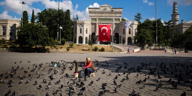 A woman waits for customers to sell food for pigeons outside the Istanbul University Tuesday, July 19, 2016. Turkey's state-run news agency says courts have ordered 85 generals and admirals jailed pending trial over their roles in a botched coup attempt. Dozens of others were still being questioned. (AP Photo/Emilio Morenatti)