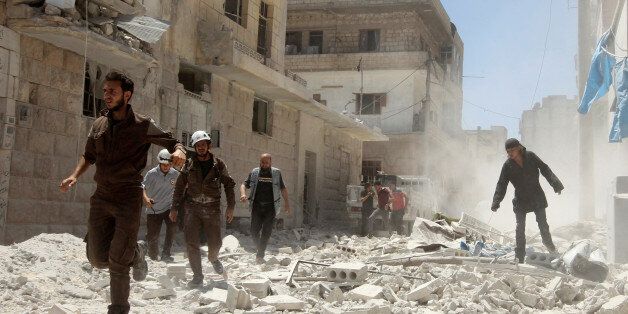 Civil Defence members work at a site hit by air strikes in Idlib city, Syria July 20, 2016. REUTERS/Ammar Abdullah