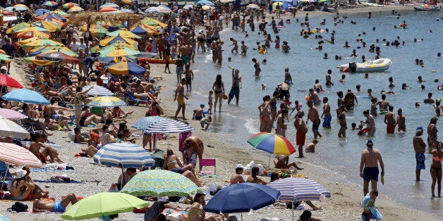 People enjoy the sunny weather on the beach of Alimos, south of Athens, Greece, July 12, 2015. Euro zone leaders will fight to the finish to keep near-bankrupt Greece in the single currency on Sunday after the European Union's chairman canceled a planned summit of all 28 EU leaders that would have been needed in case of a