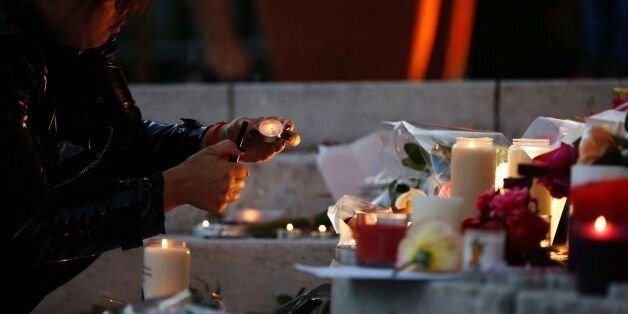 A woman lits a candle near flowers and messages displayed in front of the city hall of the Normandy city of Saint-Etienne du Rouvray on July 26, 2016 in tribute to the priest killed in the city's church in the latest of a string of attacks against Western targets claimed by or blamed on the Islamic State jihadist group.French President said that two men who attacked a church and slit the throat of a priest had 'claimed to be from Daesh', using the Arabic name for the Islamic State group. Police said they killed two hostage-takers in the attack in the Normandy town of Saint-Etienne-du-Rouvray, 125 kilometres (77 miles) north of Paris. / AFP / CHARLY TRIBALLEAU (Photo credit should read CHARLY TRIBALLEAU/AFP/Getty Images)