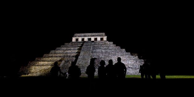 FILE - In this March 10, 2008 file photo, journalists appear silhouetted against a Mayan temple, before covering the meeting of 'Indigenous People to Heal Our Mother Earth'' in Palenque, Mexico. Archaeologists at Palenque have discovered an underground water tunnel built under the Temple of Inscriptions, which houses the tomb of Mayan ruler Pakal. Archaeologists believe the tunnels were built to give Pakal's spirit a path to the underworld. (AP Photo/Alexandre Meneghini, File)