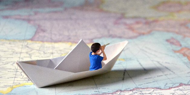 Imaginative sea travel through a paper map. A kid looking for a adventure in other countries.