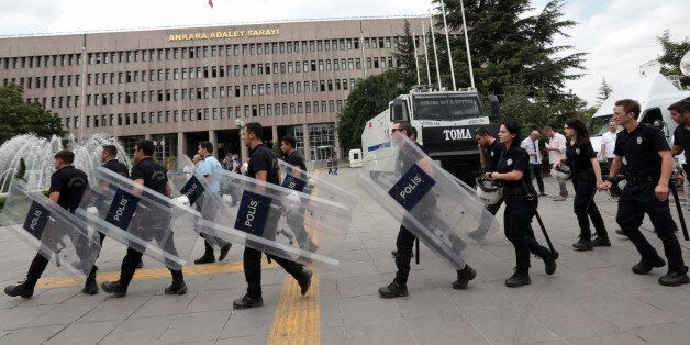 Turkish riot police officers arrive to take positions at the courthouse where prosecutors are questioning hundreds of coup plotters, in Ankara, Turkey, Wednesday, July 20, 2016. Turkey's National Security Council is holding an emergency meeting following a coup attempt last week that was derailed by security forces and protesters loyal to the government. President Recep Tayyip Erdogan was heading the meeting Wednesday of the council, which is the highest advisory body on security issues. (AP Photo/Burhan Ozbilici)