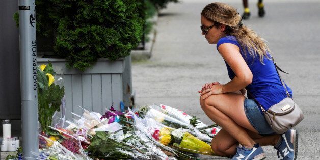 A woman lays flowers on a makeshift memorial at the Consulate General of France in Manhattan following the Nice terror attack in New York, U.S., July 16, 2016. REUTERS/Eduardo Munoz