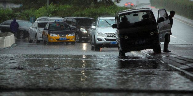 A motorist looks at a flooded underpass during a rainstorm in Beijing, Wednesday, July 20, 2016. A strong weather system brought heavy rain to China's capital on Wednesday. (AP Photo/Mark Schiefelbein)