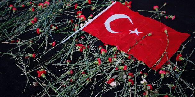 A Turkish flag lies on a bed of carnations left in the memory of civilians and police officers killed during the attempted coup, in central Istanbul's Taksim Square, Thursday July 21, 2016. Turkish lawmakers convened to endorse sweeping new powers for Turkey's President Recep Tayyip Erdogan that would allow him to expand a crackdown in the wake of July 15 failed coup. (AP Photo/Emrah Gurel)
