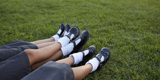 Closeup of legs of 3 schoolgirls in uniforms