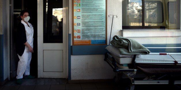 TO GO WITH AFP STORY BY SOPHIE MAKRIS A nurse stands in a doorway at a hospital on the eastern Greek island of Samos on January 20, 2015. Greece's economic woes mean that paramedics on the picturesque island of Samos are increasingly faced with the terrible dilemma of who to save and who to leave to die. On January 25, Greeks vote in a general election for the second time in three years, with radical leftists Syriza leading the polls with a promise to renegotiate the international bailout that has imposed five years of austerity on the country. AFP PHOTO / ARIS MESSINIS (Photo credit should read ARIS MESSINIS/AFP/Getty Images)