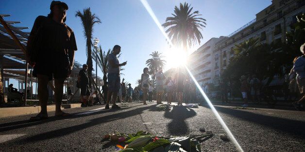 People lay flowers at the site of a deadly truck attack on the famed Promenade des Anglais in Nice, southern France, Saturday, July 16, 2016. French Interior Minister Bernard Cazeneuve says that the truck driver who killed 84 people when he careened into a crowd at a fireworks show was