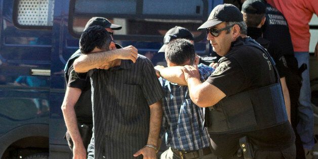 Turkish military personnel who were aboard a Blackhawk military helicopter are transferred to a prosecutor's office in the city of Alexandroupolis, northern Greece, Sunday July 17, 2016. A Blackhawk military helicopter with seven Turkish military personnel and one civilian landed in the Greek city, where the passengers requested asylum. While Turkey demanded their extradition, Greece said it would hand back the helicopter and consider the men's asylum requests. (Giannis MoÎ¹siadis/InTime News via AP) GREECE OUT