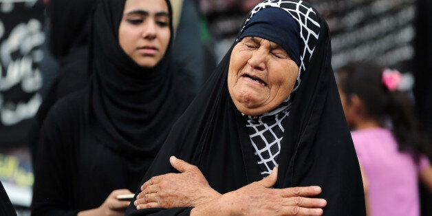 A woman grieves during a symbolic funeral for the victims of a massive truck bombing last Sunday that killed at least 186 people and was claimed by the Islamic State group, in the Karada neighborhood of Baghdad, Iraq, Sunday, July 10, 2016. (AP Photo/Hadi Mizban)