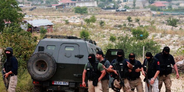 Members of the Albanian special police prepare to search a house in the village of Lazarat June 17, 2014. Police raided a cannabis plantation in a lawless Albanian village on Monday, exchanging fire with locals who responded with anti-tank grenades and heavy machineguns. There were no casualties in the gun battle in Lazarat, a village some 150 km (100 miles) south of the capital Tirana that has long been a no-go area for police who risk being shot at by drugs gangs. REUTERS/Arben Celi (ALBANIA - Tags: DRUGS SOCIETY CRIME LAW)