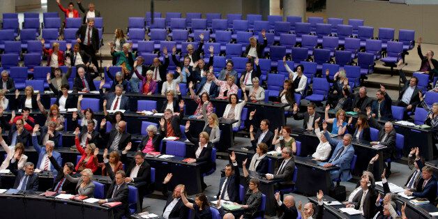 Lawmakers cast their vote during a meeting of the German Federal Parliament, Bundestag, at the Reichstag building in Berlin, Germany, Thursday, June 2, 2016. The German Parliament votes Thursday on whether to label the killings of Armenians by Ottoman Turks a century ago as genocide. (AP Photo/Michael Sohn)