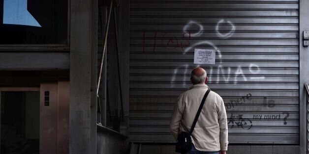 A man reads an announcement while a writing reads 'I m hungry' at a closed urban railway station in Athens, on May 6, 2016, during a 48-hours public transport strike. Greece's labour unions stage a two-day general strike to protest against controversial government plans to overhaul pensions and increase taxes to meet demands of its bailout creditors. / AFP / LOUISA GOULIAMAKI (Photo credit should read LOUISA GOULIAMAKI/AFP/Getty Images)