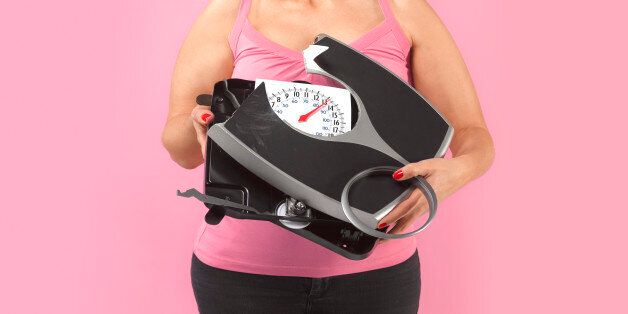 Obese woman with broken weighing scales.