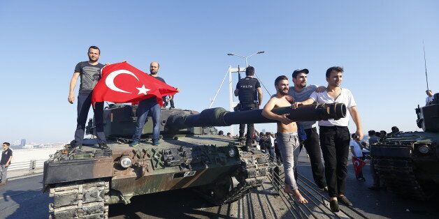People pose near a tank after troops involved in the coup surrendered on the Bosphorus Bridge in Istanbul, Turkey July 16, 2016. REUTERS/Murad Sezer