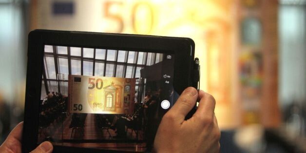 A man takes apicture with atablet computer of the new 50 EURO banknote presented at the European Central Bank, ECB in Frankfurt/Main, Germany, on July 5, 2016. / AFP / DANIEL ROLAND (Photo credit should read DANIEL ROLAND/AFP/Getty Images)