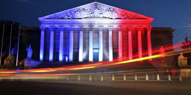 Cars pass by the National Assembly illuminated in the French national colors in honor of the victims of Thursday's attack in Nice, south of France, in Paris Friday, July 15, 2016. As new details emerged Friday about the Tunisian man who drove a truck through crowds celebrating Bastille Day in Nice, killing at least 80 people and wounding hundreds others, French leaders extended a state of emergency imposed after the Nov. 13 Paris attacks and vowed to deploy thousands of police reservists on the streets. (AP Photo/Thibault Camus)