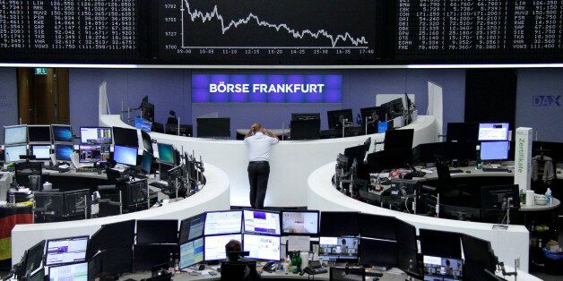 Traders work at their desks in front of the German share price index, DAX board, at the stock exchange in Frankfurt, Germany, July 4, 2016. REUTERS/Staff/Remote