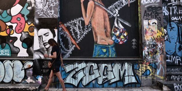 A woman walks by a graffiti reading 'Exit' on July 5, 2016 in central Athens, one year after the Greek referendum, where 62 percent of population voted 'No' to further austerity measures. / AFP / LOUISA GOULIAMAKI (Photo credit should read LOUISA GOULIAMAKI/AFP/Getty Images)