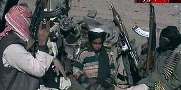 Picture taken from Al Jazeera television purportedly shows Hamza bin Osama bin Laden (C), one of the sons of Saudi-born dissident Osama bin Laden, seated between two Taliban fighters near Ghazni Afghanistan. [ U.S. B-52 bombers continued to pound the front line of Taliban forces north of the Afghan capital November 7, 2001. ] POOR QUALITY VIDEO DOCUMENT (CREDIT REUTERS/Al-Jazeera TV)