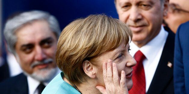 German Chancellor Angela Merkel (C) reacts next to Afghanistan's Chief Executive Abdullah Abdullah (L) and Turkey's President Tayyip Erdogan as they observe a fly past during the NATO Summit in Warsaw, Poland July 8, 2016. REUTERS/Kacper Pempel