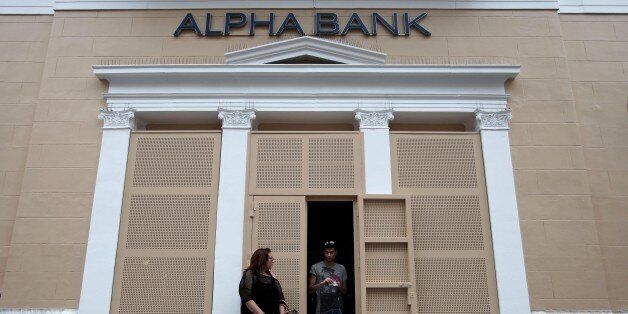 A man exits a branch of Alpha bank in Athens on Tuesday, May 29, 2012. The four biggest Greek banks received 18 billion euros (US$22.6 billion) in rescue funds on May 28, 2012 to help reinforce their capital bases, a Hellenic financial stability fund source said. National Bank, the biggest Greek lender, has received 7.43 billion euros, Piraeus bank 4.7 billion euros, Eurobank 3.97 billion euro and Alpha 1.9 euros billion, the official said. (AP Photo/Petros Giannakouris)