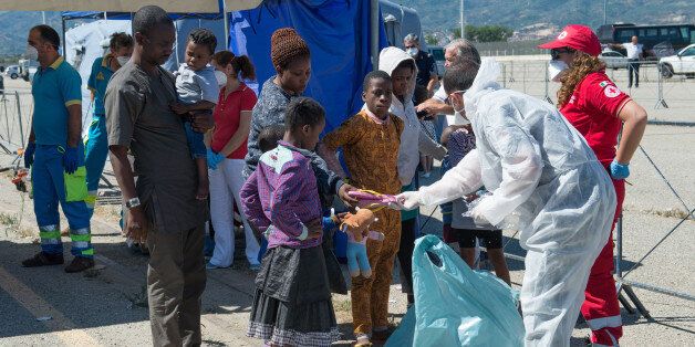 CALABRIA, ITALY - 2016/06/29: Volunteers distribute shoes to migrants landed by Roisin Irish Navy ship in the port of Corigliano from which landed 498 sub-Saharan migrants including 71 women and 91 unaccompanied minors and a Syrian family. They come in particular from Nigeria, Mali, Ethiopia, Eritrea, Ghana and Cameroon. In the last two days are over 1,000 landed immigrants and more than 7000 in the last period in the ports of southern Italy. (Photo by Alfonso Di Vincenzo/Pacific Press/LightRocket via Getty Images)
