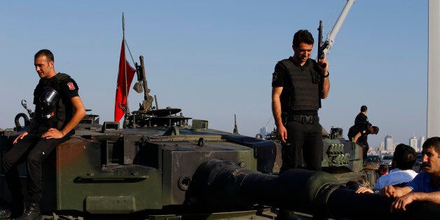 Turkish police officers, loyal to the government, stand atop tanks abandoned by Turkish army officers, near Istanbul's iconic Bosporus Bridge, Saturday, July 16, 2016. Turkish President Recep Tayyip Erdogan declared he was in control of the country early Saturday as government forces fought to squash a coup attempt during a night of explosions, air battles and gunfire that left dozens dead. (AP Photo/Emrah Gurel)