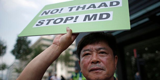 A South Korean man holds a sign during a rally to denounce deploying the Terminal High-Altitude Area Defense, or THAAD, near U.S. Embassy in Seoul, South Korea, Monday, July 11, 2016. Seoul and Washington launched formal talks on deploying the Terminal High-Altitude Area Defense, or THAAD, after North Korea conducted a nuclear test and a long-range rocket launch earlier this year. China, Russia and North Korea all say the THAAD deployment could help U.S. radars spot missiles in their countries. (AP Photo/Lee Jin-man)