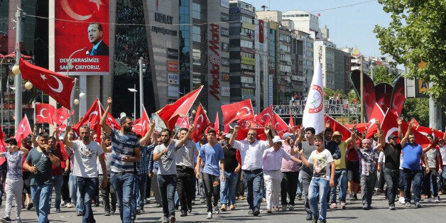 People wave national flags as they march from Kizilay square to Turkish General Staff building to react against military coup attempt, in Ankara, on July 16, 2016, following an attempt by discontented soldiers to seize power from President Recep Tayyip Erdogan that claimed more than 250 lives.After the bloodiest challenge to his 13-year autocratic rule, Erdogan urged his backers to stay on the streets to prevent a possible 'flare-up' of yesterday's chaos in the strategic NATO member of 80 million people. / AFP / ADEM ALTAN (Photo credit should read ADEM ALTAN/AFP/Getty Images)