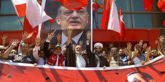 Supporters of Turkey's President Recep Tayyip Erdogan, making a four-fingered gesture referring to the 2013 killing of Muslim Brotherhood protesters at the Rabaah Al-Adawiya Mosque in Egypt, protest against the failed coup in Turkey, in front the Turkish hospital in the southern port city of Sidon, Lebanon, Saturday, July 16, 2016. Forces loyal to Turkey's president quashed a coup attempt in a night of explosions, air battles and gunfire that left dozens dead Saturday. (AP Photo/Mohammed Zaatari